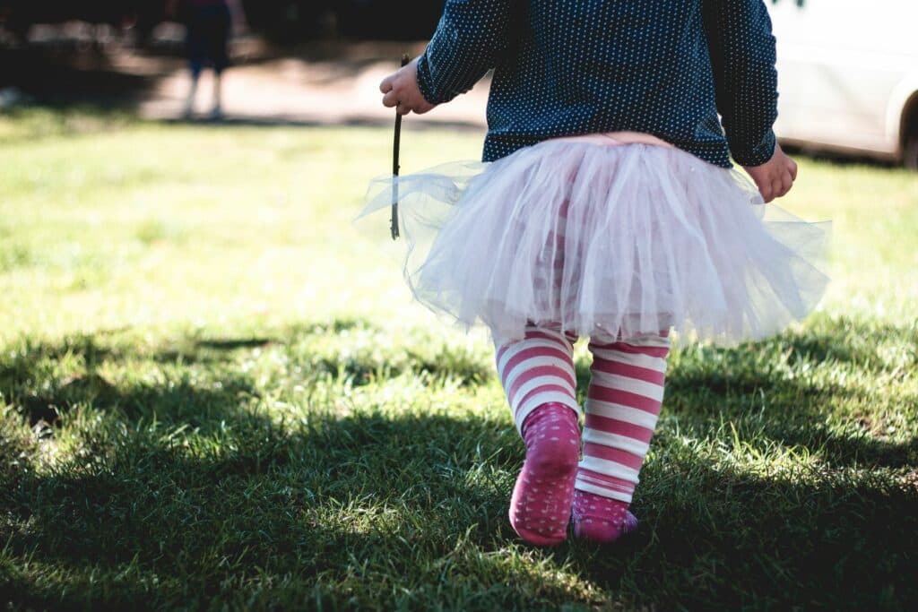Kleinkind mit Tutu geht über eine Wiese - Kinderwörter sind eine schöne Erinnerung. Eine Sammlung.