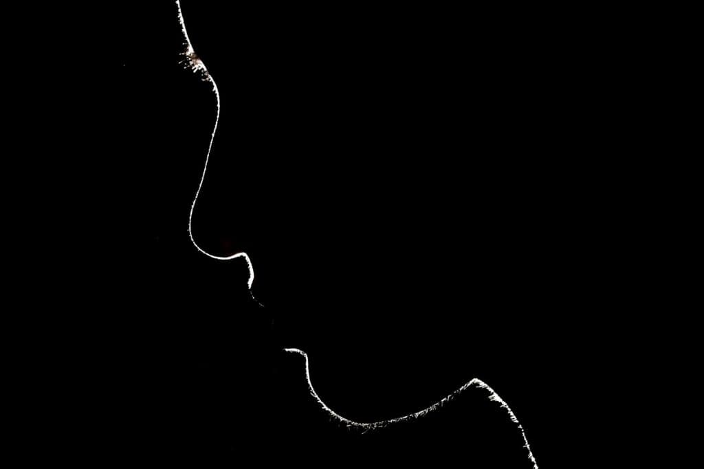 Silhouette einer Person im Schatten. Häusliche Gewalt kann jede treffen - das zeigt dieser Text.