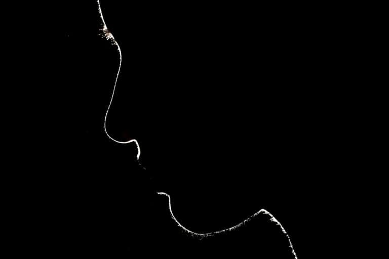 Silhouette einer Person im Schatten. Häusliche Gewalt kann jede treffen - das zeigt dieser Text.
