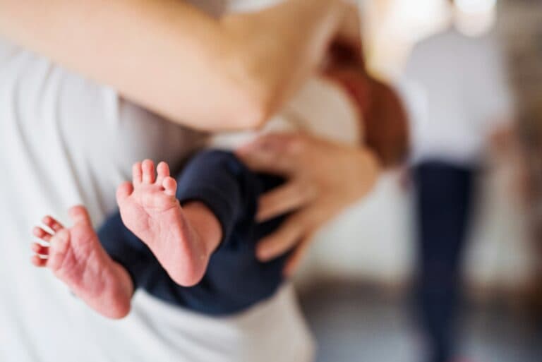 Mutter stillt ihr Baby. Babys dürfen kein Honig einnehmen.