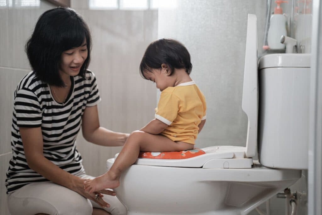 Kind sitzt auf der Toilette. Ein entzündeter Penis bei Kindern muss behandelt werden.