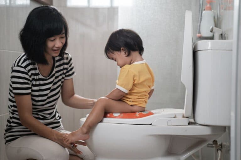 Kind sitzt auf der Toilette. Ein entzündeter Penis bei Kindern muss behandelt werden.