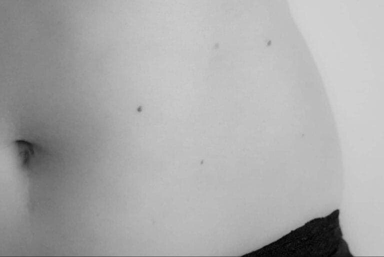 Schwarz-weiss Bild eines weiblichen Bauches. Der Mombod, der Körper einer Frau nach Schwangerschaft und Geburt, fühlt sich plötzlich fremd an.