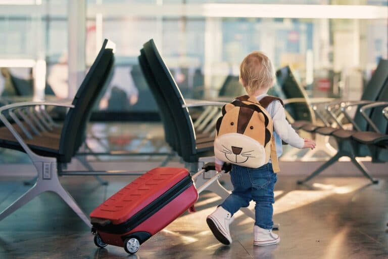 Kleinkind am Flughafen mit Köfferchen. Was muss man alles beachten beim Fliegen mit Baby und Kleinkind?