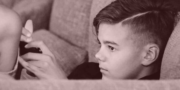 Das erstes Handy: Wann ist der richtige Zeitpunkt und welche Regeln sind sinnvoll? - Junge mit Handy auf dem Sofa - mal ehrlich