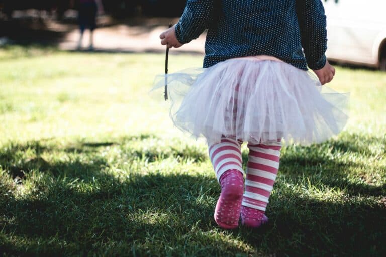 Kleinkind mit Tutu geht über eine Wiese - Kinderwörter sind eine schöne Erinnerung. Eine Sammlung.