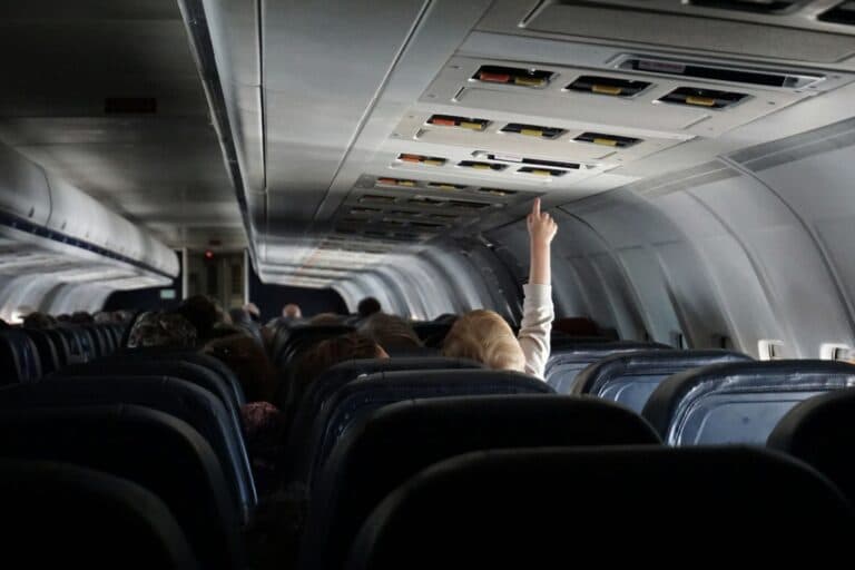 Kind streckt sich im Flugzeug nach der Decke. Wie überlebt man einen Langstreckenflug mit Kleinkind oder Baby? Wir haben erprobte Tipps.