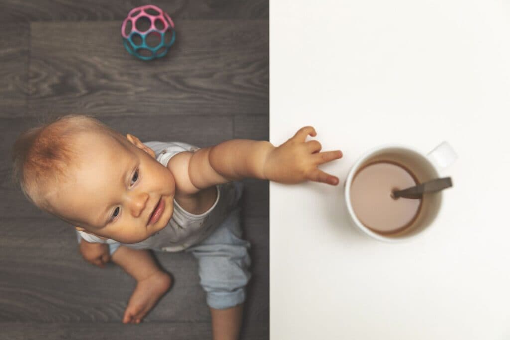 Kind greift nach heissem Kaffee auf der Kücke. Dies kann zu Verbrennungen führen