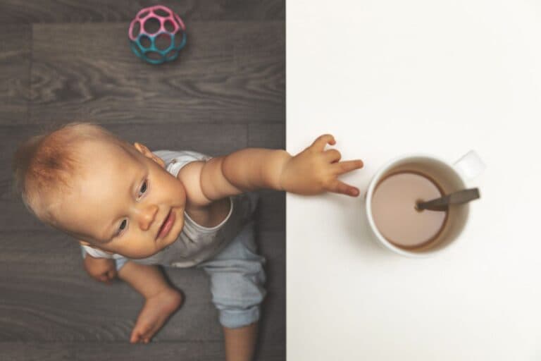 Kind greift nach heissem Kaffee auf der Kücke. Dies kann zu Verbrennungen führen