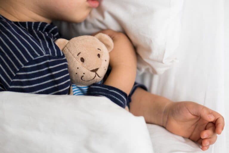 Schlafendes Kind mit Teddybär - Was tun Eltern bei Verdacht auf Hirnhautentzündung/Meningitis?