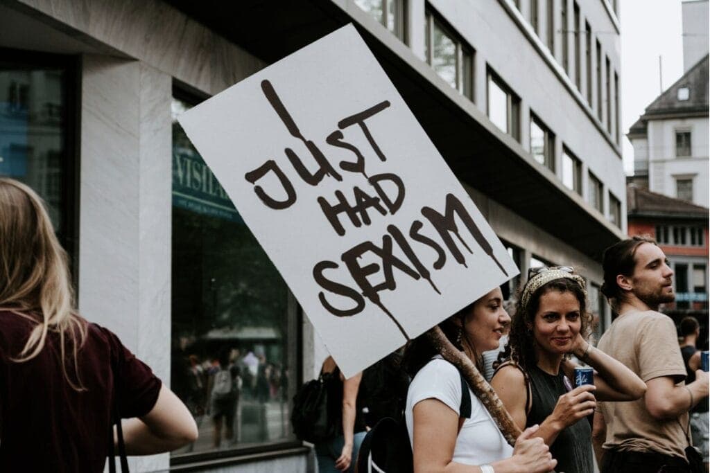 Eine Frau hält ein Transparent auf dem steht "I just had sexism" – Von Männern, die sich sexistisch verhalten und sich dann als Opfer sehen.
