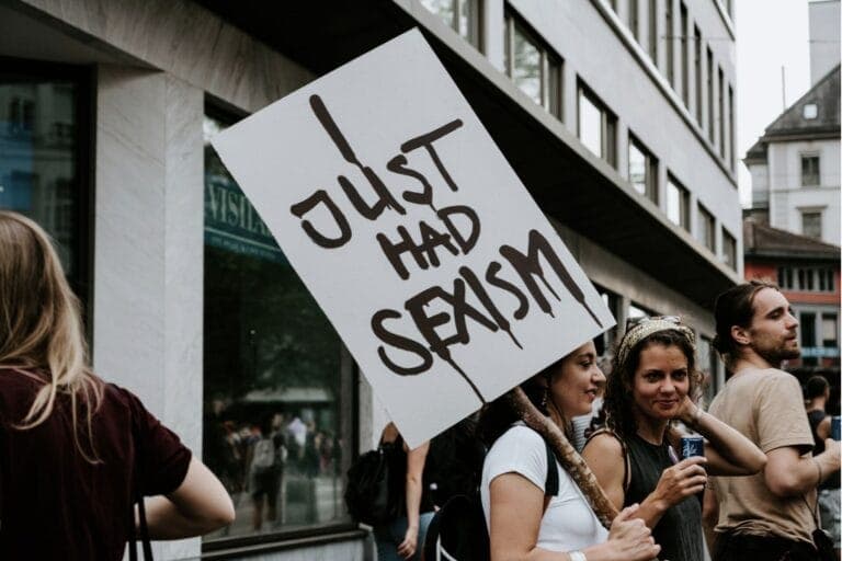 Eine Frau hält ein Transparent auf dem steht "I just had sexism" – Von Männern, die sich sexistisch verhalten und sich dann als Opfer sehen.