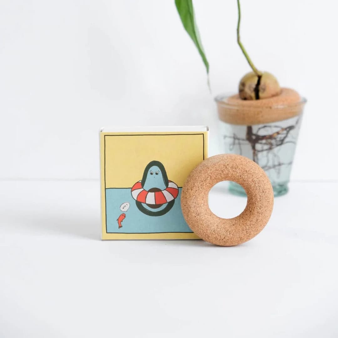 Kork-Scheibe von Pépin, mit der du aus fast jedem Avocadokern einen kleinen Avocadobaum ziehst. Handgemacht in Frankreich, Illustration Gigi.