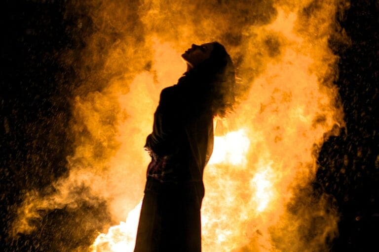 Silhouette einer Frau, die nach oben blickt. Hinter ihr ein explodierendes Feuer vor schwarzem Hintergrund. Erfahrungsbericht Wut-Seminar